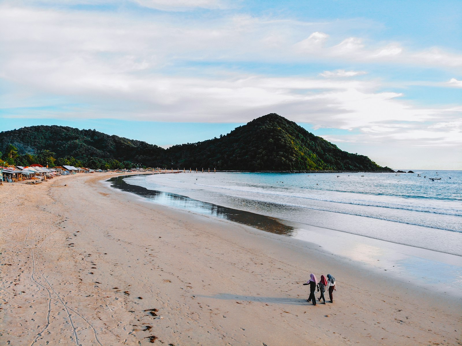 Long crescent of white sand and gentle surf at Selong Belanak bay on the south coast